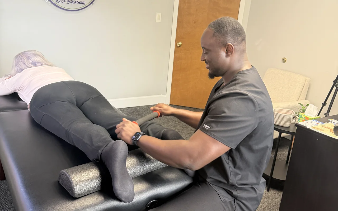 Deen Ali working a client's calf on the table at StretchOut Wellness, Tampa